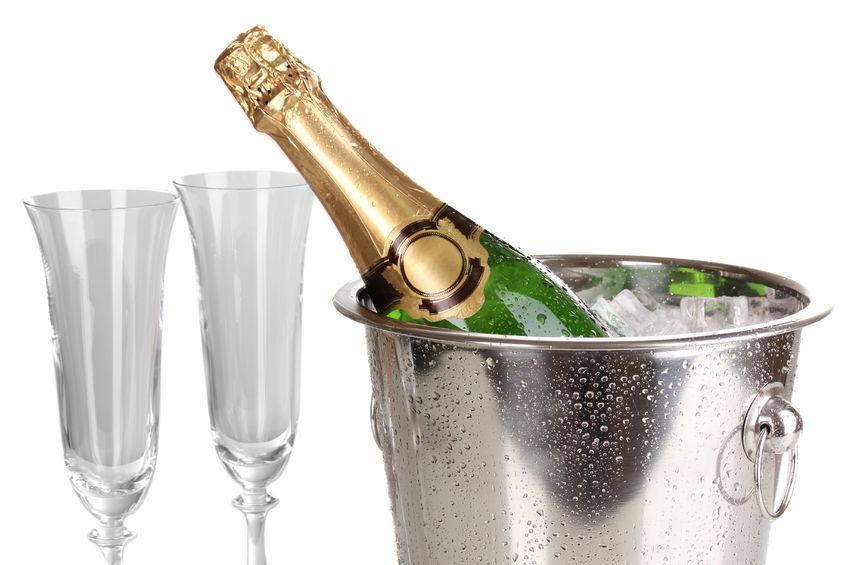 champagne bottle in bucket with ice and glasses